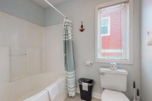 Un baño blanco con bañera y inodoro. en Charm of the Canal, en Carolina Beach 16 fotos más