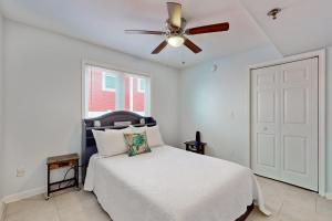Un dormitorio con una cama y un ventilador de techo. en Charm of the Canal, en Carolina Beach