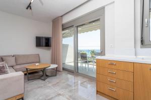 a living room with a couch and a table at Alexmare SeaView House Mola Kaliva in Mola Kalyva