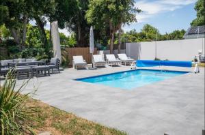 a patio with a pool and lounge chairs next to a fence at Stunning House in Constantia in Cape Town