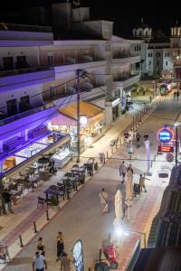 a group of people walking around a street at night at Paralia Luxury Apartment in Paralia Katerinis