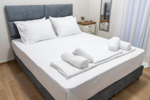 a bedroom with a bed with towels on it at Paralia Luxury Apartment in Paralia Katerinis