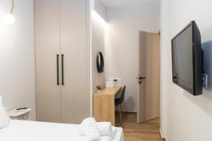 a bedroom with a bed and a desk with a tv at Paralia Luxury Apartment in Paralia Katerinis