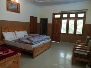 a bedroom with a bed in a room with windows at Last Resort, Sajjan Gali in Nathia Gali