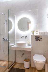a bathroom with a sink and a toilet and a mirror at Paralia Luxury Apartment in Paralia Katerinis +19 photos
