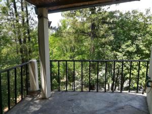 a balcony with a black railing and trees at Last Resort, Sajjan Gali in Nathia Gali +56 photos