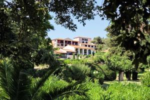 un grand bâtiment au milieu d'un jardin dans l'établissement Résidence Les Parcs de Grimaud - maeva Home - Studio 4 personnes - Sélection MAE-4361, à Grimaud