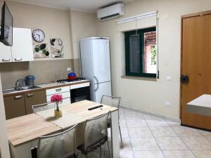 a kitchen with a table and a refrigerator at A Casa di nonna Emilia in Campagna +16 photos