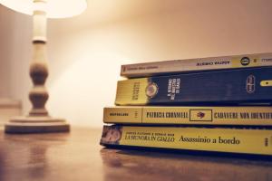 a stack of books on a table next to a lamp at Piccolo Navy in Livorno