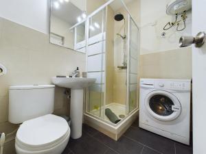 a bathroom with a toilet and a sink and a washing machine at Hidden Gem Hideaway Retreat in Central Town Area with AC in Gibraltar +10 photos