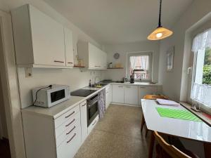 a kitchen with white cabinets and a microwave at Van Kim 1 Ferienwohnung in Emden
