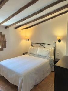 a bedroom with a bed with white sheets and pillows at Apartamentos turísticos "El Refugio" in Algar de Palancia