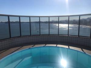a swimming pool with a view of the water at Paraíso à vista Cobertura Linear Canto Nobre in Guarapari
