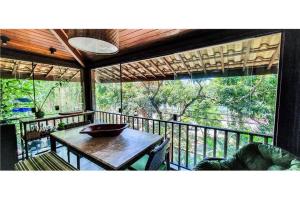 d'un balcon avec une table et une vue sur la forêt. dans l'établissement Village Lagoa do Forte, à Mata de São João
