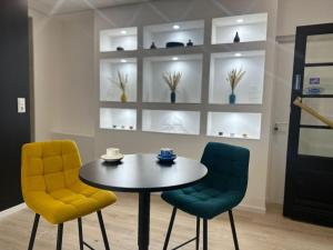 阿让Maison des ambans chambres d'hotes hypercentre 200m de la gare et petit dejeuner inclus的一间带桌子和两把椅子的用餐室