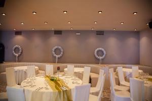 a dining room with white tables and white chairs at Galini Palace in Athens