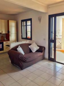 a living room with a brown couch in a kitchen at FronteMare in San Cataldo +14 photos