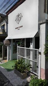 a building with a fence and a sign on it at Friend's House Arak in Chiang Mai