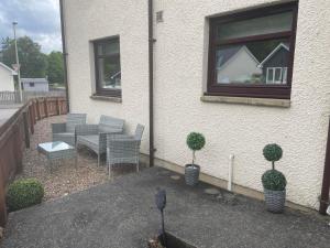 a patio with a table and chairs and a window at 5 The Galleries in Spean Bridge