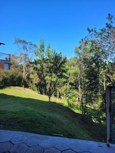 uma colina relvada com uma árvore no topo em Suite Ana - Casa Tapera Nova em Conceição da Ibitipoca