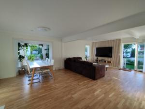 a living room with a couch and a table at Villa with the garden in Hokksund