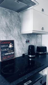 a kitchen with a black counter top and white cabinets at Lansdowne Apartments in Hartlepool +7 photos