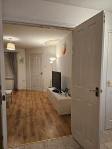 a living room with a television on a table and a door at The Park view, 2 Bedroom House in Kirkcaldy +22 photos