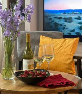 a table with a bowl of strawberries and wine glasses at Studio Olesińska in Warsaw