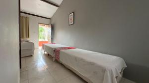 a bedroom with two beds and a window at Pousada Mutary in Santa Cruz Cabrália