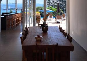 een houten tafel in een kamer met uitzicht op de oceaan bij Mirante Mar de Minas - Casa para Temporada Lago de Furnas pertinho dos Canyons in São José da Barra