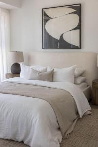a bedroom with a large white bed with white pillows at L'Escale d'Ulysse in La Marsa
