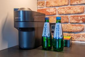 two bottles of beer sitting next to a coffee maker at Studio Olesińska in Warsaw