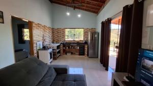 een woonkamer met een bank en een keuken bij Sítio Ramos casa da montanha in Cunha