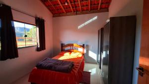 een kleine slaapkamer met een bed en een raam bij Sítio Ramos casa da montanha in Cunha