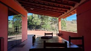 een tafel en stoelen in een kamer met uitzicht bij Sítio Ramos casa da montanha in Cunha