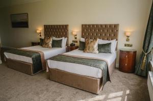 a hotel room with two beds and two lamps at Crover House Hotel & Golf Club in Mountnugent