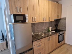 a kitchen with wooden cabinets and a stainless steel refrigerator at Villa Toni II in Biograd na Moru