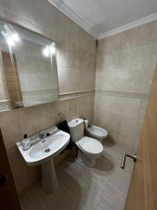 a bathroom with a sink and a toilet and a mirror at Apartamento en Isla Cristina in Isla Cristina +7 photos