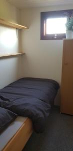 a small bedroom with a bed and a window at De Greidefûgel in Westergeest