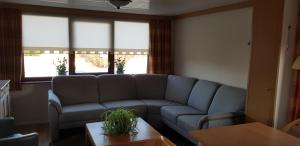 a living room with a couch and a table at De Greidefûgel in Westergeest +4 photos