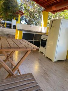 a picnic table and a refrigerator on a patio at Pousada Chalés Praia Vermelha in São João Batista do Glória