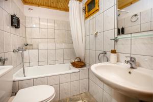 a bathroom with a toilet and a sink and a tub at Etherio House in Skala Sotiros +67 photos