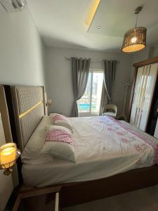 a bedroom with a bed with pillows and a window at 3bedroom chalet double view in AMWAJ in El Alamein +8 photos