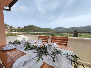 a table with plates and glasses on a balcony at Antoni Apartment in Lastovo
