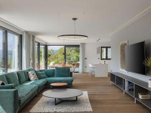 a living room with a green couch and a tv at Villa Adria Blue in Kraljevica