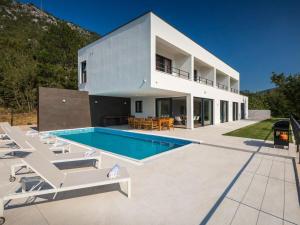 a villa with a swimming pool and lounge chairs at Villa Adria Blue in Kraljevica