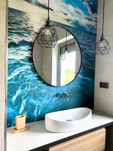 un baño con lavabo y espejo en APARTAMENTY Wakacyjna 53 Dziwnówek, Wrzosowo, en Dziwnówek 64 fotos más