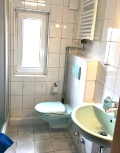 a bathroom with a toilet and a sink and a window at HOSTEL 66 Bremerhaven Geestland in Imsum +36 photos