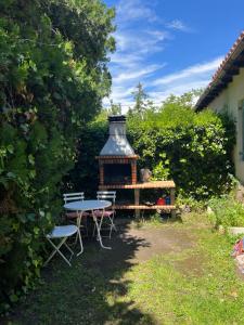 a table and chairs in a garden with a gazebo at LA MALINCHE in Segovia