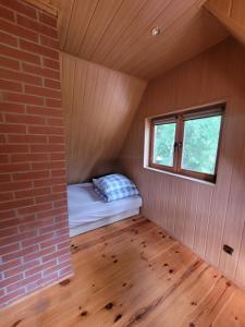 a small room with a bed and a window at Domek nad jeziorem Głębokie in Głębokie